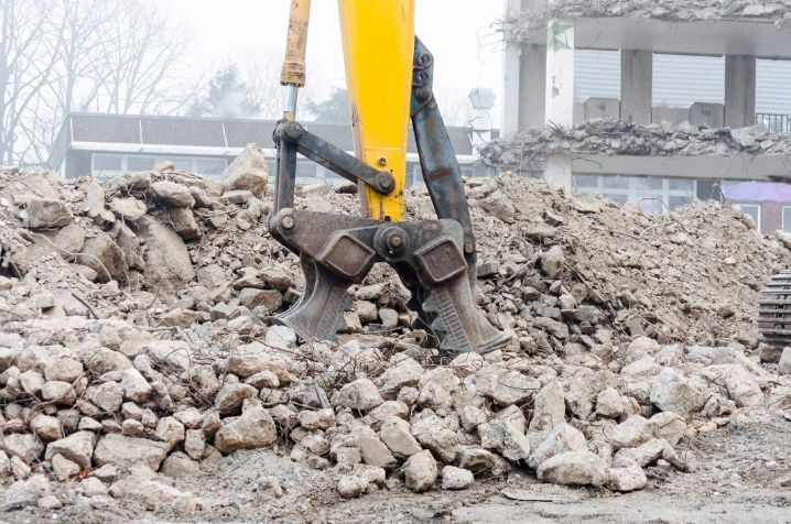 Massive crusher chopping up concrete in smaller chunks for transportation on an industrial site