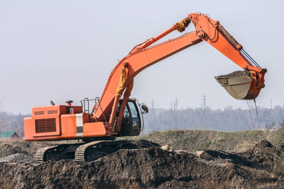 Orange Excavator excavating on an Industrial site