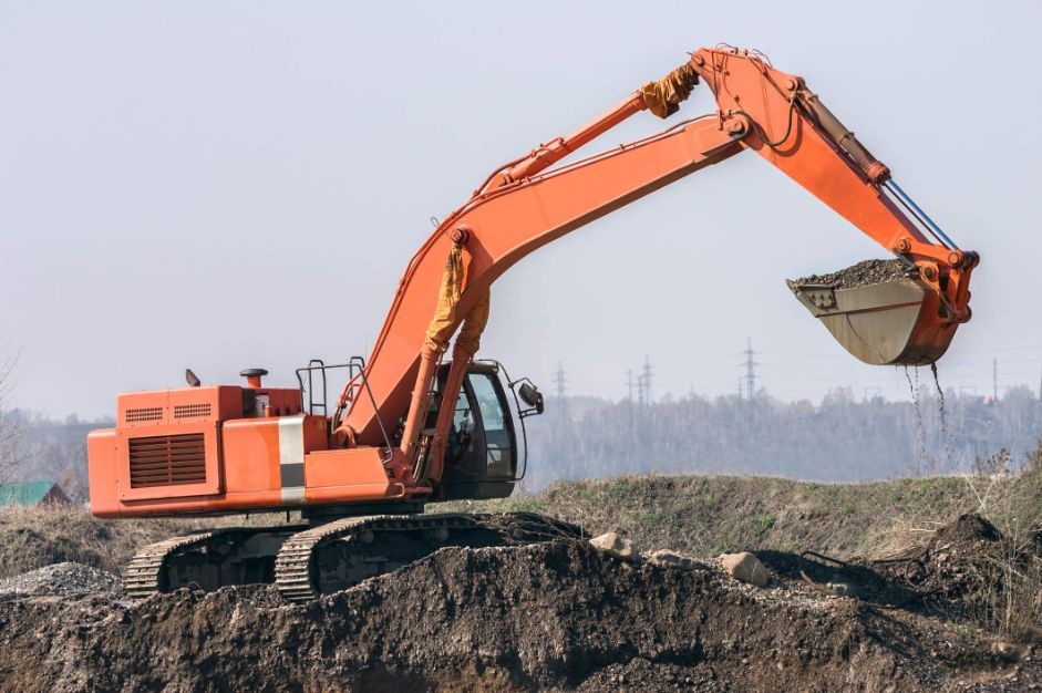 GRND-Industrial-Excavation-Services Orange Excavator excavating on an Industrial site