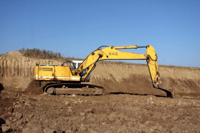 Excavator levelling an industrial excavation site