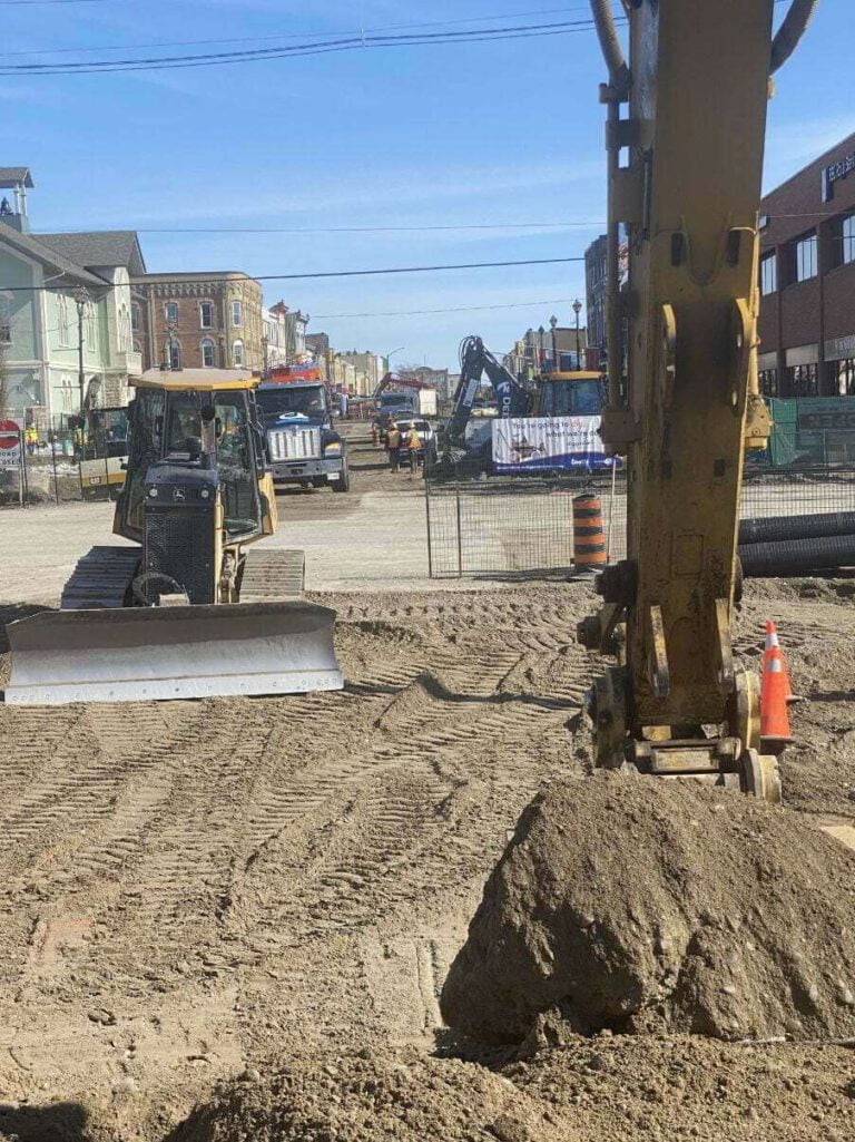 excavation by moving soil on a commercial parking lot with an excavator and bulldozer