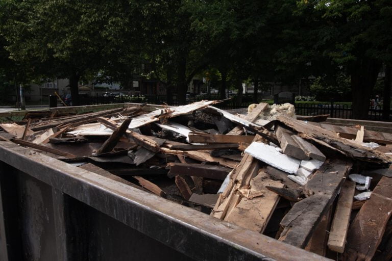 mostly wood demolition debris in a full bin that is ready for transport