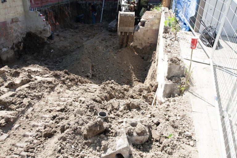 using an excavator to move soil from one side of the property to the other