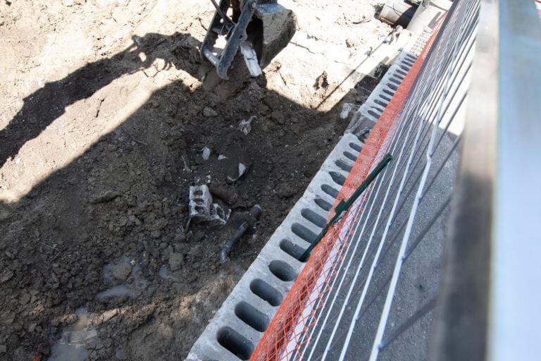 Moving parts of old concrete with an excavator for later removal off-site