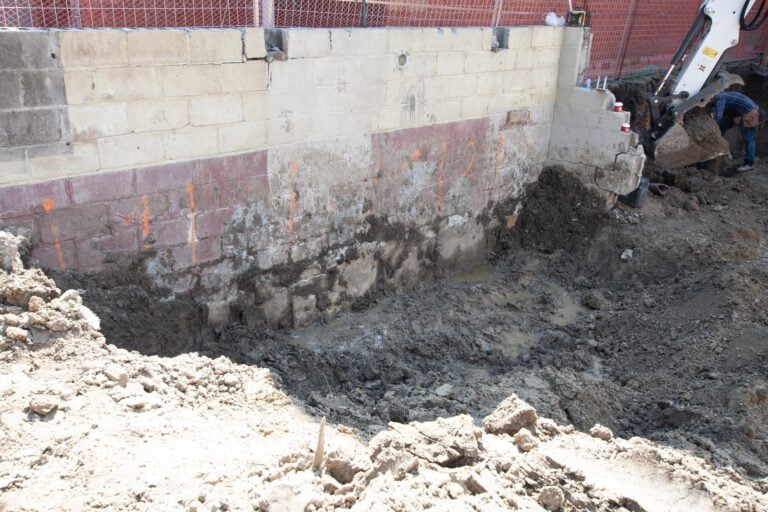 removing soil with an excavator in preparation for underpinning