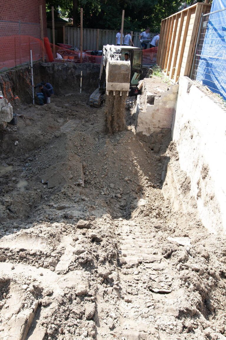 moving soil with an excavator to level the ground, with a laser level ensuring the height is correct