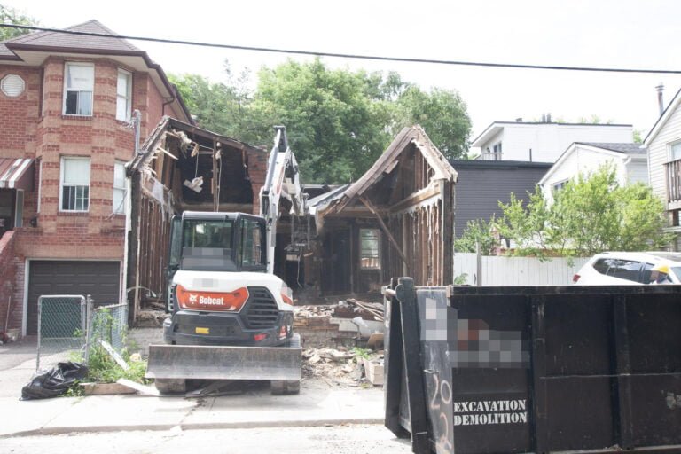 home demolition project in Toronto where an excavator is demolishing the roof