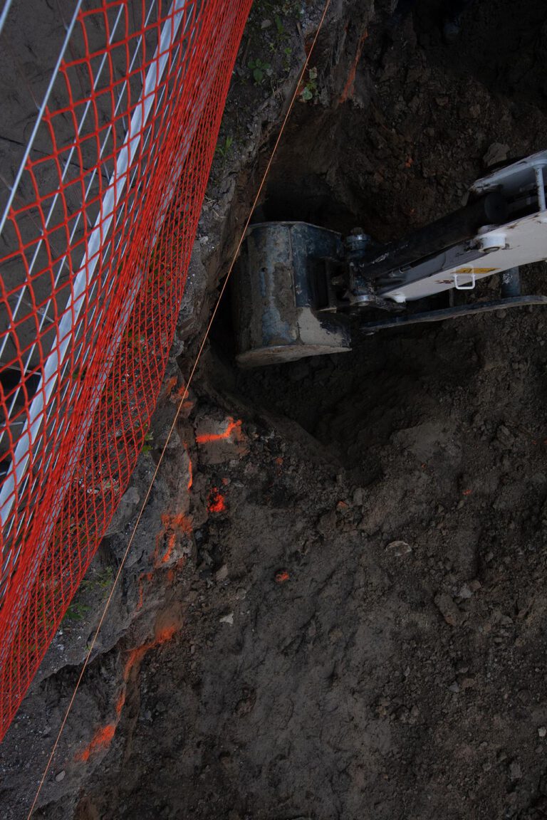 digging holes under a property wall by means of an excavator
