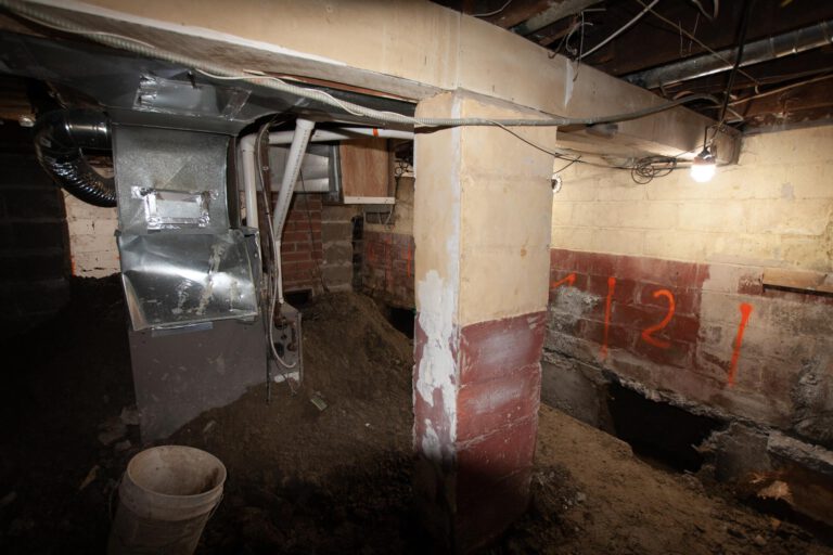 basement underpinning in progress with writing on the wall for exact measurement underpinning