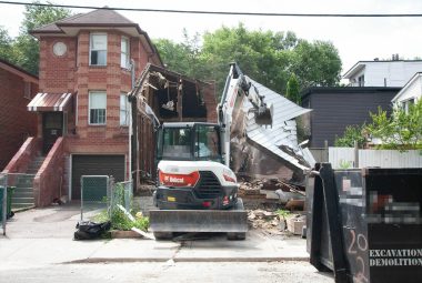 Demolition of a house by means of an excavator at a residential demolition job site in Toronto, ON
