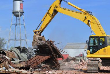 Excavator moving industrial demolition waste for recycling pickup